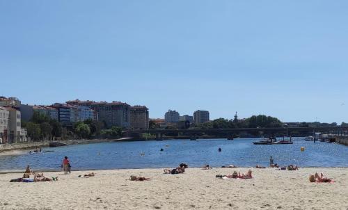 a group of people laying on the beach on the water at La casita by DADO in Vigo
