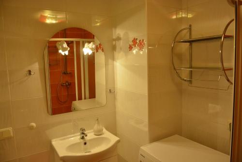a bathroom with a sink and a toilet and a mirror at Neringaholiday Apartamentai in Juodkrantė