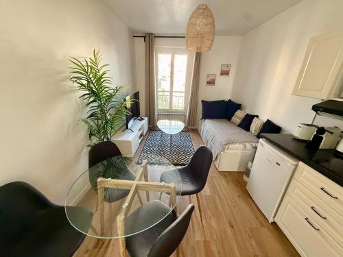 un salon avec une table en verre et un canapé dans l'établissement La Maison Cosy Paris Centre - Métro - Wifi, au Kremlin-Bicêtre