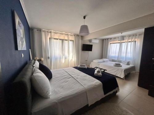 a hotel room with two beds and a television at Mytilene Luxury Villa Panoramic in Mytilini