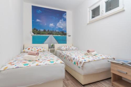 two beds in a bedroom with a view of the ocean at Beachfront villa Mihovil with direct beach access in Kastel Stafilic