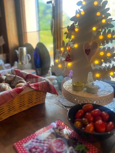 a table with a basket of food and a tree with lights at B&B Apart Hotel Goldener Hahn - Hygge Pool & Sauna in Baiersbronn