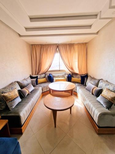 a living room with a couch and a table at Appartement la perle bleu in Agadir