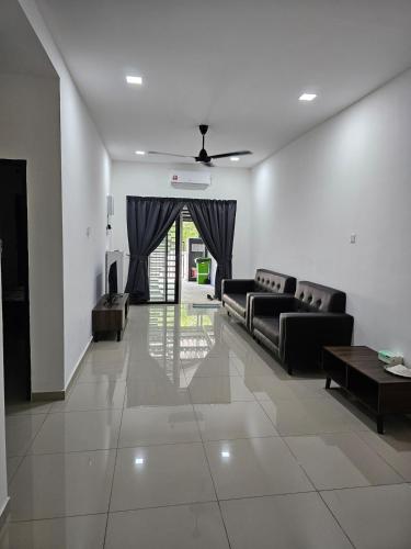 a living room with couches and a ceiling fan at Green View Homestay in Kuantan