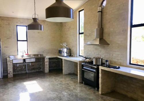 une grande cuisine avec une cuisinière et un évier dans l'établissement AlteVrede Olive Farm, à Doornrivier