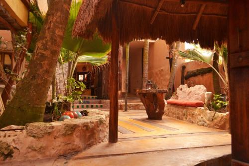 an entrance to a resort with a straw umbrella at La Posada del Sol Boutique Hotel Tulum in Tulum