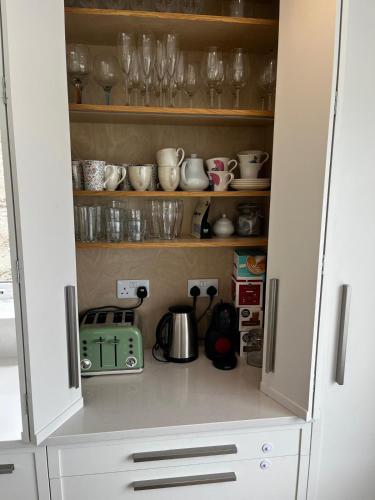 a cupboard filled with lots of glasses and utensils at Dooneen House in Clifden