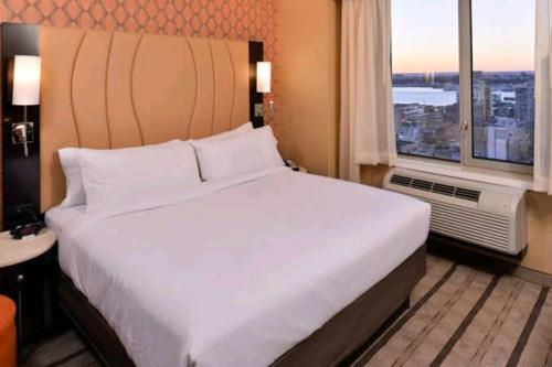 a large bed in a hotel room with a window at Hotel Aladin In Karachi in Karachi