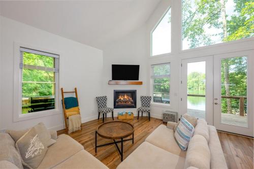 a living room with a couch and a fireplace at Unwind at Lakey McLakehouse on Lake Santeetlah in Robbinsville