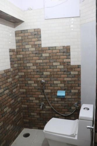 a bathroom with a toilet and a brick wall at Mordhwaj in Jodhpur