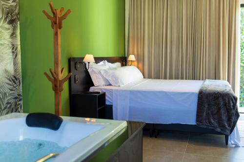 a bathroom with two beds and a bath tub at Pousada Flor de Piri in Pirenópolis