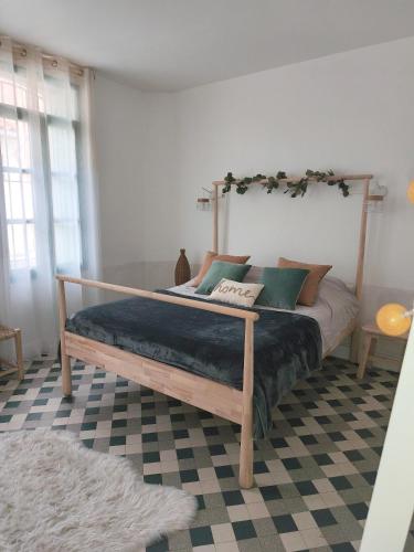 - une chambre avec un lit doté d'un cadre en bois dans l'établissement Appartement central maison Marceau, à Rivesaltes