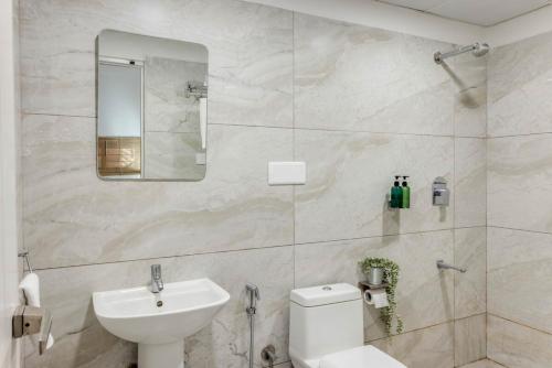 a bathroom with a sink and a toilet and a mirror at Spacious 3 BHK apartment in Shanti Nagar in Jāmb