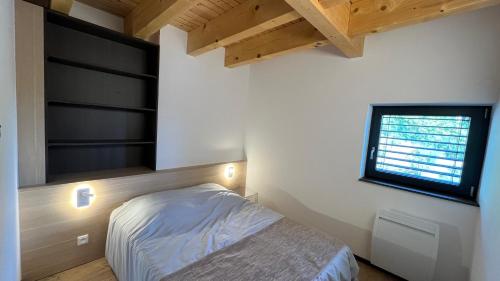 a small bedroom with a bed and a window at KITTERLELODGE Suite 1 à 4 personnes avec vue in Guebwiller