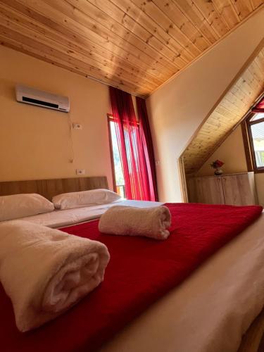 a bedroom with a bed with two towels on it at Guest House Shtëpiza Theth in Theth