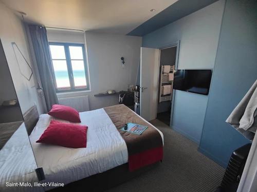 a bedroom with a bed with red pillows on it at Hôtel Ar Iniz in Saint Malo