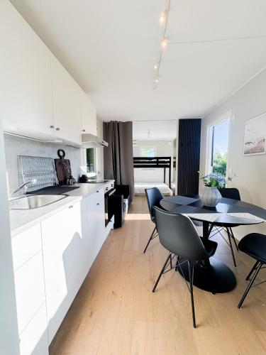 a kitchen and dining room with a table and chairs at Lakefront cabin on Skåne's largest island in Ivö