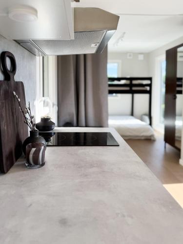 a kitchen with a counter top and a room with a bed at Lakefront cabin on Skåne's largest island in Ivö