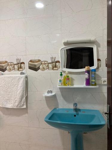 a bathroom with a blue sink and a mirror at Tetuán 2025 in Tetouan