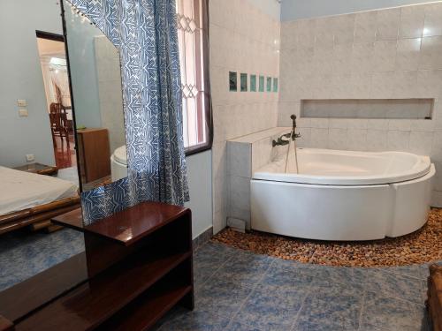 a white tub in a bathroom with a shower at White Tree Melon Villa in Puducherry