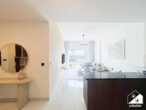 a white living room with a mirror and a couch at 2BR Vibe Spot l Pool Access & Stunning City Views in Dubai