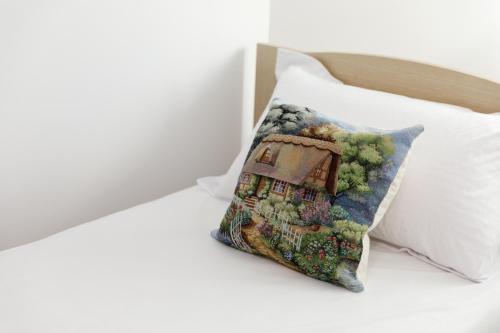 a pillow with a picture of a house on a bed at Kashah Residence in Gjirokastër