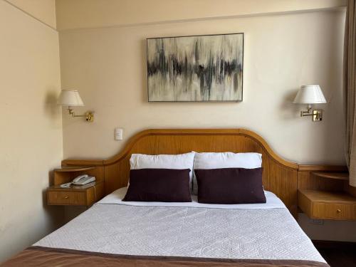 a bedroom with a bed with two pillows at Intimo Hotel Miraflores in Santiago