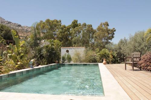 a swimming pool in a garden with a wooden deck at Finca Altozano - Private pool - Unique client in Valle de Abdalagís