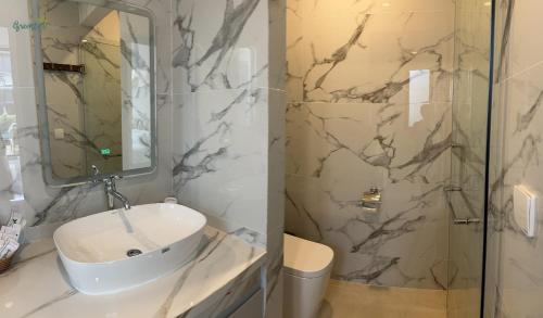 a white bathroom with a sink and a shower at Greenlife Village Phú Quốc in Phu Quoc