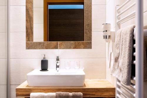 a bathroom with a white sink and a mirror at Pension Neururer in Sölden
