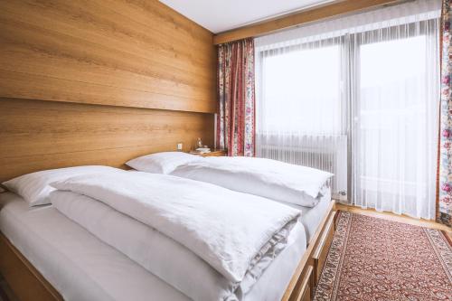 two beds in a bedroom with a window at Pension Neururer in Sölden