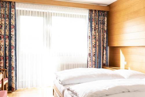 two beds in a bedroom with a window at Pension Neururer in Sölden