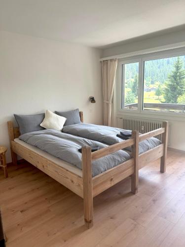 a bed in a room with a large window at Gorgeous Modern Mountain View Flat in Täsch in Täsch