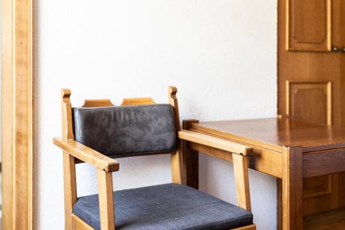 a wooden chair sitting next to a wooden table at Pension Neururer in Sölden