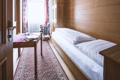 a bedroom with a bed and a table and a window at Pension Neururer in Sölden