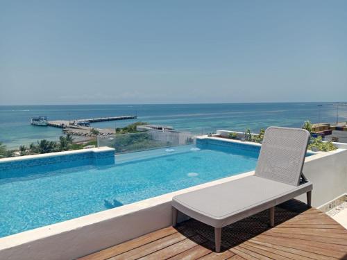a chair sitting on a deck next to a swimming pool at Turix 102 in Puerto Morelos