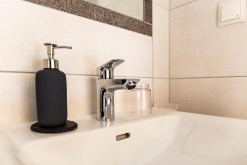 a bathroom sink with a soap dispenser on it at Pension Neururer in Sölden