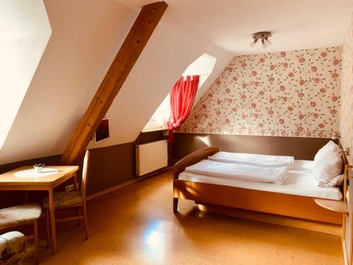 a bedroom with a bed and a table at Weinhof Michael Morbach in Zeltingen-Rachtig