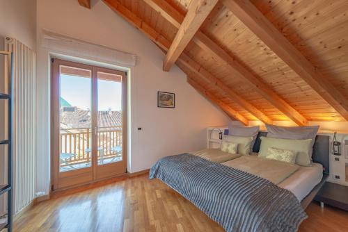 a bedroom with a bed and a large window at Maison sous le ciel in Caldaro