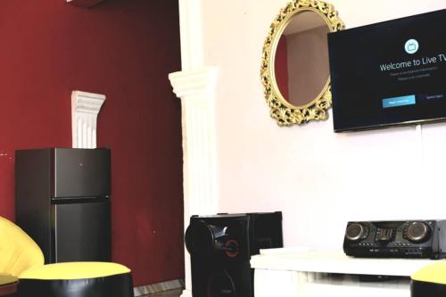 a room with a microwave and a mirror and a tv at Cerra's lodge in Otta