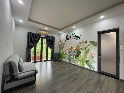 a living room with a couch and a sign on the wall at SATURDAY Homestay Tuy Hòa - Phú Yên in Tuy An