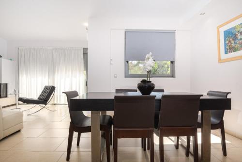 a dining room with a black table and chairs at Villa Anavil - Boutique Coastal Retreat in Varkiza in Vari