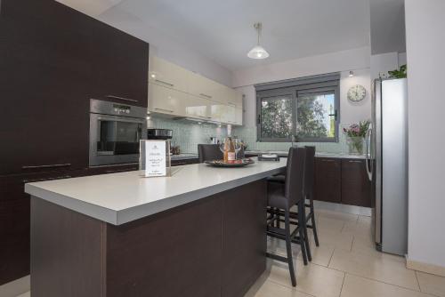 a kitchen with a large island in the middle at Villa Anavil - Boutique Coastal Retreat in Varkiza in Vari