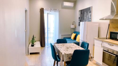 un salon avec une table et un canapé bleu dans l'établissement Confort & clim Logement 4 pers proche gare, centre et Polygone, à Béziers