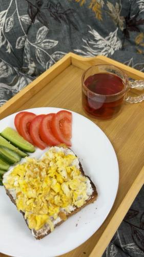 a slice of pizza on a plate with tomatoes and cucumbers at Hotel Aladin In Karachi in Karachi