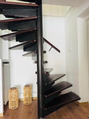 a black spiral staircase in a room with two baskets at Dom wakacyjny z podgrzewanym basenem w tarasie i jacuzzi pod gwiazdami, Studnica, Ińsko, "THerapeutica" 