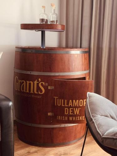a whiskey barrel with two bottles on top of it at Dom wakacyjny z podgrzewanym basenem w tarasie i jacuzzi pod gwiazdami, Studnica, Ińsko, "THerapeutica" 