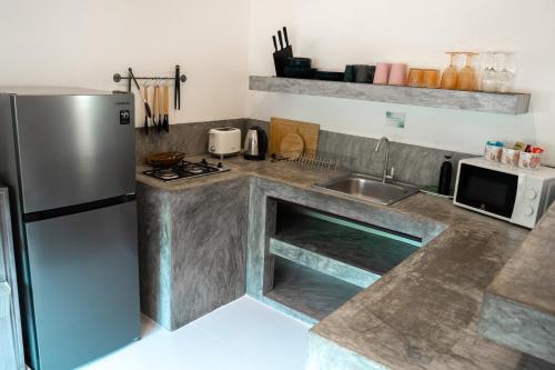 a kitchen with a stainless steel refrigerator and a sink at Chalisa Villas Koh Tao in Koh Tao