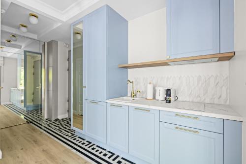 ソポトにあるWilla Na Wydmach Sopot by OneApartmentsの白いキャビネットと鏡付きのキッチン