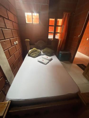 a large white bed in a small room at Mi pueblo natal Aptos y habitaciones in Necoclí